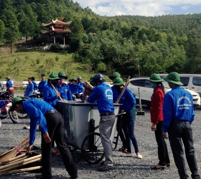 Các đoàn viên thanh niên tham gia dọn dẹp vệ sinh xung quanh khu mộ Đại tướng Võ Nguyên Giáp.