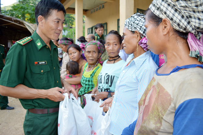 Đại úy Trịnh Tứ Thắng trao quà cho đồng bào Mày ở bản Lòm, xã Trọng Hóa, huyện Minh Hóa.