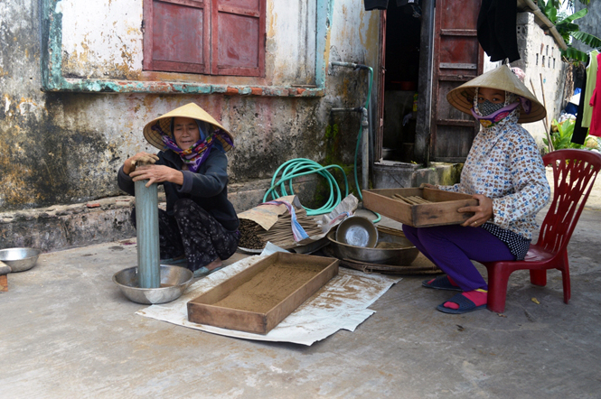 Nhúng hương vào bột trầm rẹ quạt để hoàn thành sản phẩm.