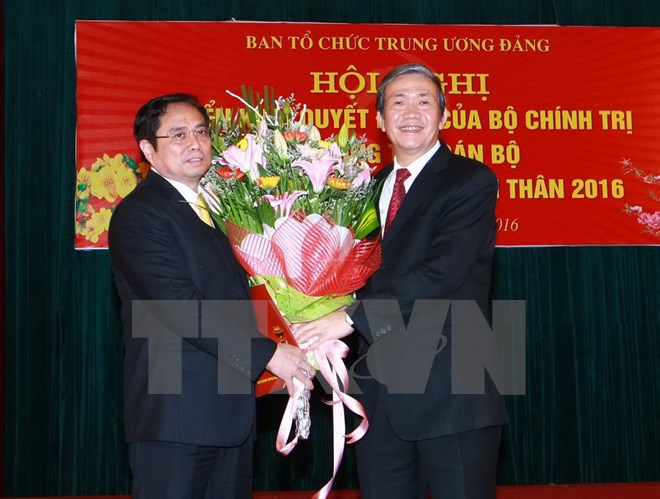 Ông Đinh Thế Huynh, Ủy viên Bộ Chính trị, Thường trực Ban Bí thư trao Quyết định và tặng hoa cho ông Phạm Minh Chính. (Ảnh: Doãn Tấn/TTXVN)