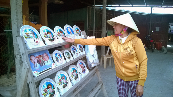 Có hàng chục hộ dân bán hàng hoa, ảnh lưu niệm trên tuyến đường vào khu mộ Đại tướng.