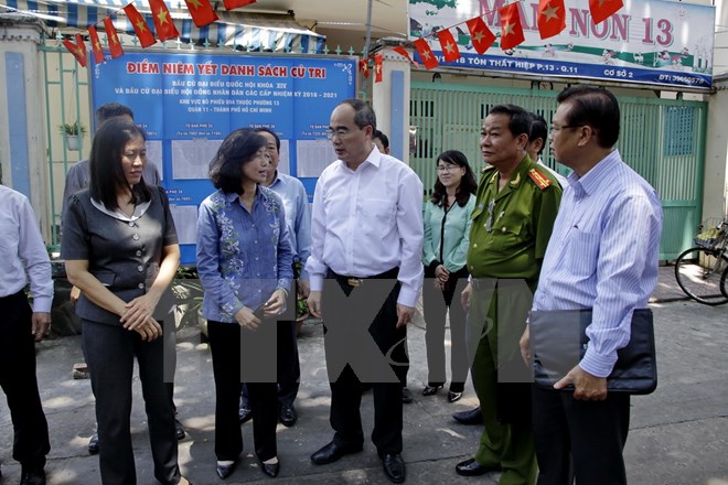 Ông Nguyễn Thiện Nhân cùng đoàn công tác kiểm tra thực địa một số điểm niêm yết danh sách cử tri trên địa bàn Quận 11. (Ảnh: Thế Anh/TTXVN)