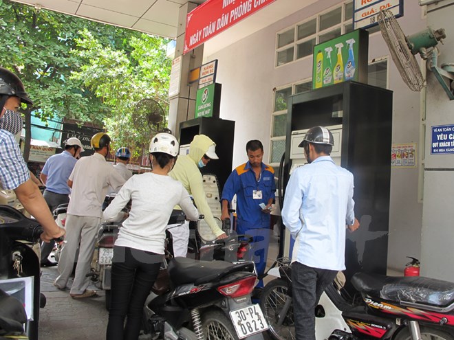 Nhân viên Petrolimex đang bơm xăng cho khách hàng (Ảnh: Đức Duy/Vietnam+)