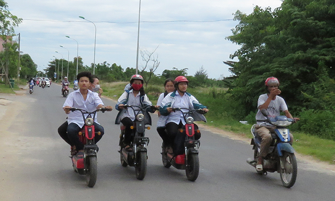 Học sinh đi xe dàn hàng ngang và không đội mũ bảo hiểm, hình ảnh dễ bắt gặp trên đường.