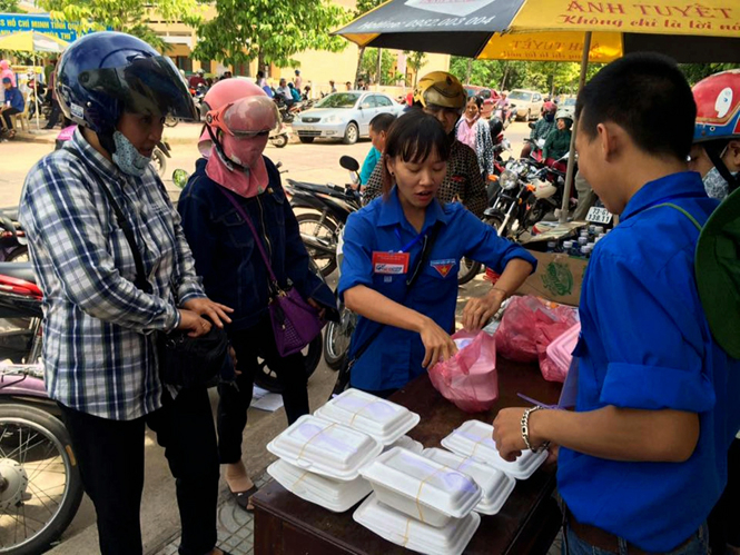 Đội tình nguyện tiếp sức mùa thi Thành đoàn Đồng Hới bán cơm giá rẻ cho các thí sinh và người nhà thí sinh.