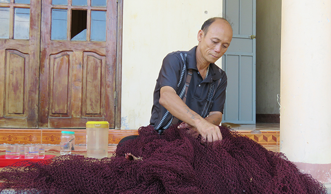 Ông Trương Xuân Duấn bên những tấm lưới cũ.