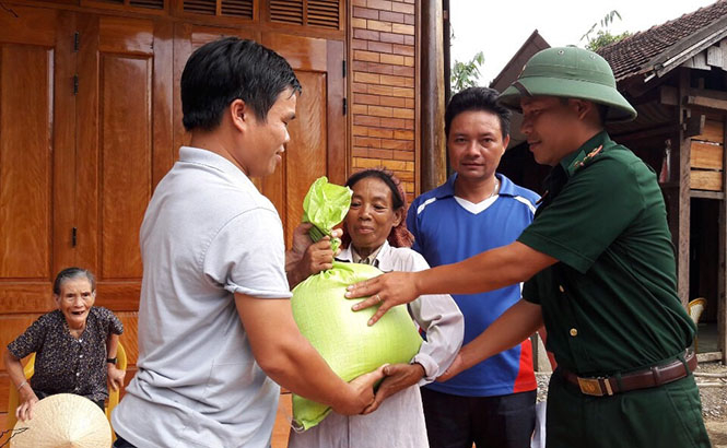 Đồn biên phòng Cà Xèng phối hợp với địa phương cấp phát gạo cho đồng bào. 