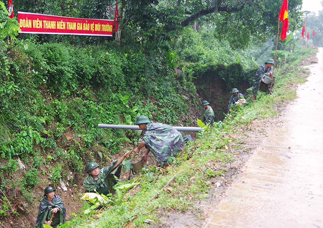 Chiến sỹ Trung đoàn 996, nạo vét kênh mương, thu dọn rác thải dưới trời mưa.