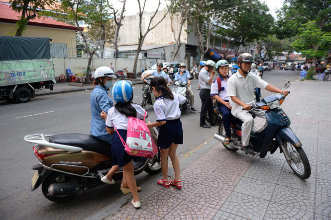 Phụ huynh đưa con đến học thêm tại một cơ sở ở Q.1, TP.HCM - Ảnh: HỮU KHOA