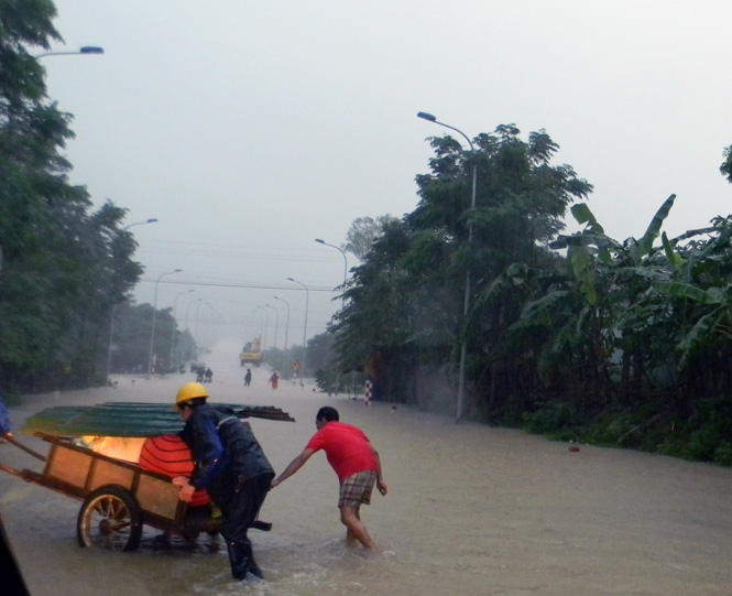 Người dân xã Văn Hoá di chuyển đồ đạc đến nơi an toàn để tránh lũ.