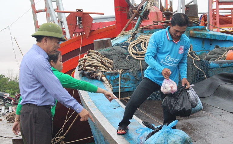 Đồng chí Nguyễn Hữu Hoài, Phó Bí thư Tỉnh ủy, Chủ tịch UBND tỉnh thăm hỏi các thuyền viên tàu cá neo đậu tại cảng Gianh