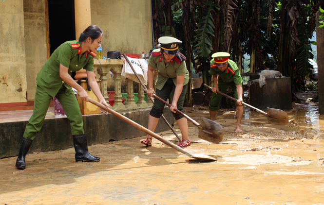 Công an huyện Bố Trạch giúp nhân dân dọn dẹp sau khi nước lũ rút.