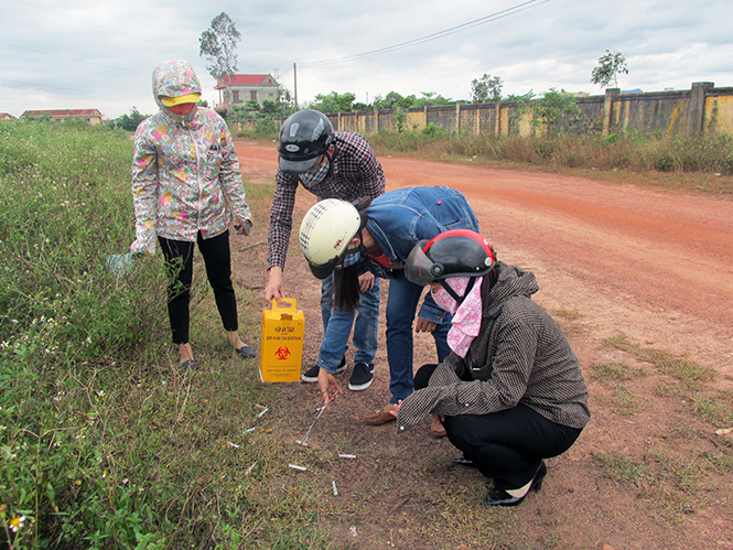 Nhân viên tiếp cận cộng đồng phòng chống HIV/AIDS  đang thu gom bơm kim tiêm bẩn do người nghiện ma túy để lại ở các cộng đồng dân cư.