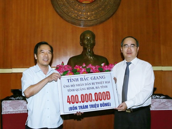 Chủ tịch Ủy ban Trung ương Mặt trận Tổ quốc Việt Nam Nguyễn Thiện Nhân tiếp nhận 400 triệu đồng của cán bộ và nhân dân tỉnh Bắc Giang ủng hộ đông bào. (Ảnh: Nguyễn Dân/TTXVN)