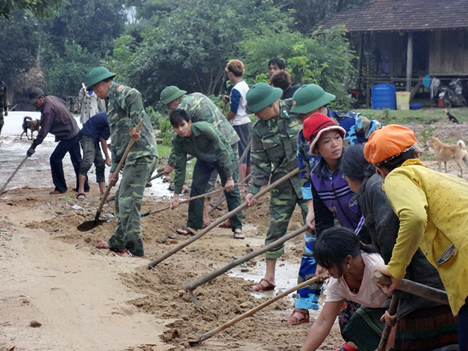 Cán bộ, chiến sĩ Đồn biên phòng Làng Ho giúp nhân dân trên địa bàn đóng quân khắc phục hậu quả trận lũ lụt trung tuần tháng 10-2016. Ảnh: Nguyễn Tài