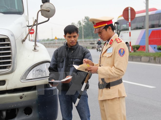 Cảnh sát giao thông trạm Tân Đệ kiểm tra các phương tiện trên tuyến QL10, đoạn qua địa bàn huyện Vũ Thư. (Ảnh: Xuân Tiến/TTXVN)