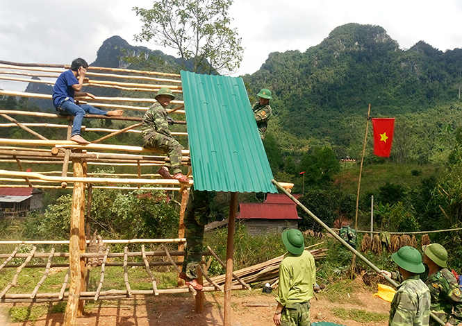 Cán bộ, chiến sỹ Đồn Biên phòng Cồn Roàng giúp dân dựng nhà.