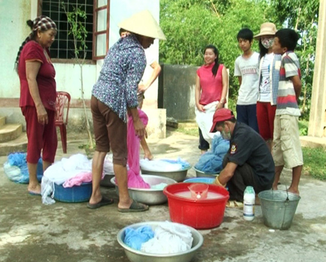 Cán bộ y tế giúp bà con tẩm màn hoá chất phòng chống muỗi.