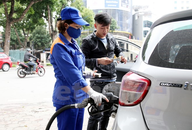 Nhân viên Petrolimex đang bán xăng cho khách hàng. (Ảnh: Doãn Đức/Vietnam+)