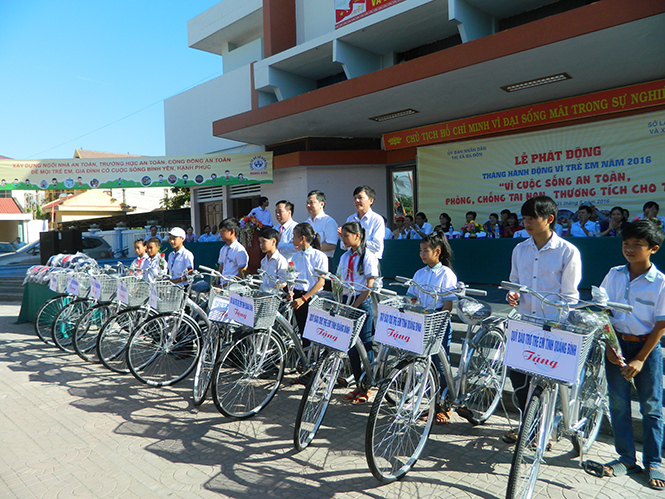 Đại diện lãnh đạo tỉnh và các đơn vị, địa phương liên quan trao quà cho các em học sinh có hoàn cảnh đặc biệt khó khăn trên địa bàn thị xã Ba Đồn.