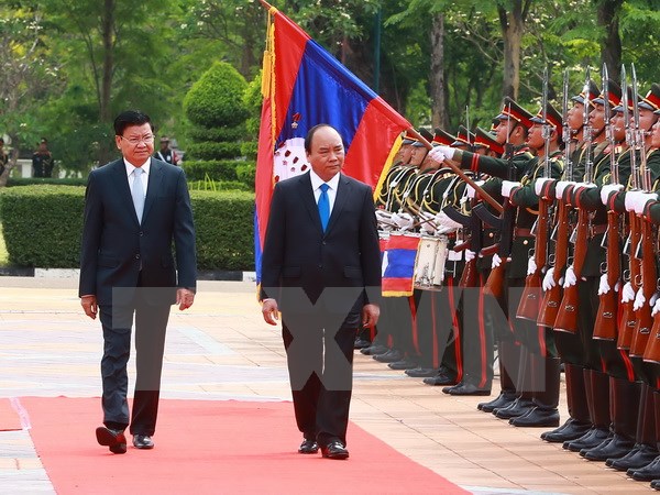 Thủ tướng Nguyễn Xuân Phúc và Thủ tướng Lào Thongloun Sisoulith duyệt Đội danh dự. (Ảnh: Thống Nhất/TTXVN)