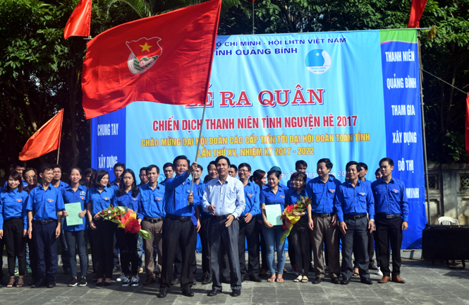 ảnh phát động tháng thanh niên. Đồng chí Nguyễn Công Huấn, Uỷ viên Ban Thường vụ, Trưởng Ban Dân vận Tỉnh ủy  trao cờ phát động thi đua thực hiện chiến dịch thanh niên tình nguyện hè cho tuổi trẻ Quảng Bình