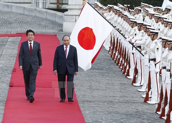 Thủ tướng Nhật Bản Shinzo Abe và Thủ tướng Nguyễn Xuân Phúc duyệt Đội danh dự tại Lễ đón chính thức. (Ảnh: Thống Nhất/TTXVN)