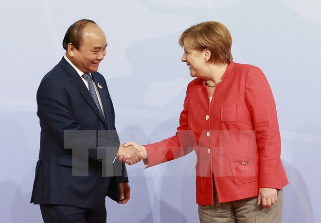 Thủ tướng Đức Angela Merkel đón Thủ tướng Nguyễn Xuân Phúc. (Ảnh: Thống Nhất/TTXVN)