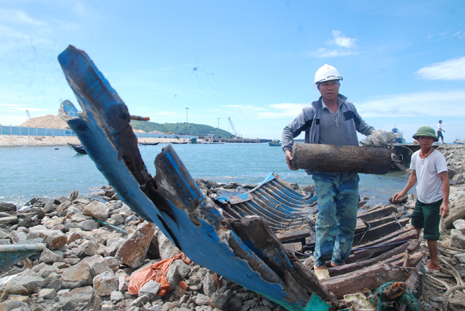 Anh Phan Đức Long, trú thôn Thọ Sơn, xã Quảng Đông lượm những vật dụng còn sót lại trên tàu đã bị sóng đánh vỡ.  