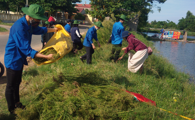 Đoàn viên thanh niên tham gia dọn dẹp vệ sinh môi trường tại xã Lộc Ninh (TP. Đồng Hới).