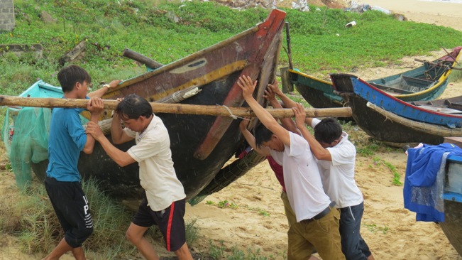 Người dân Nhân Trạch tập trung lực lượng hỗ trợ nhau đưa những chiếc tàu thuyền cuối cùng lên bờ