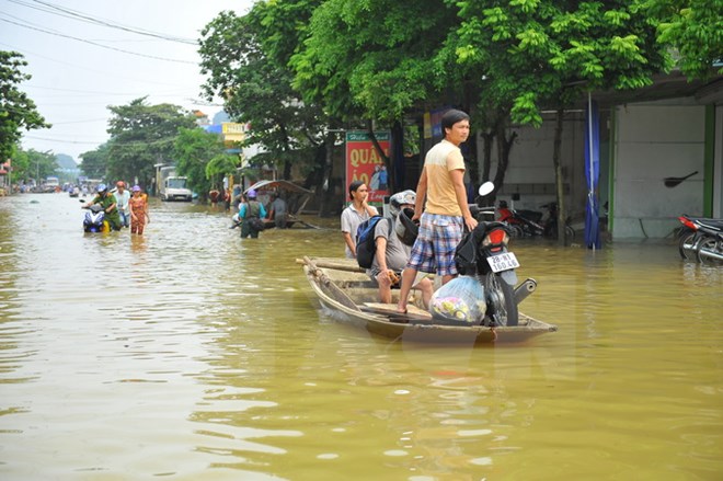 Phương tiện qua QL 477 địa phận xã Lạc Vân, huyện Nho Quan được chở bằng đò. (Ảnh: Minh Đức/TTXVN)