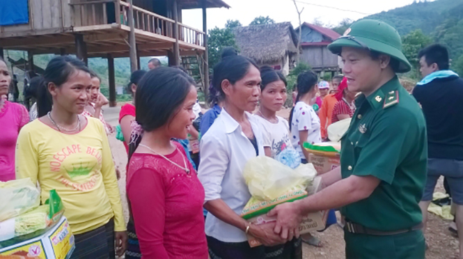 Cán bộ, chiến sỹ Đồn Biên phòng Làng Mô trao quà hỗ trợ đồng bào trên địa bàn xã Trường Sơn ổn định cuộc sống sau bão.