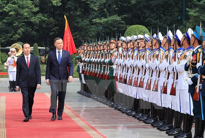 Chủ tịch nước Trần Đại Quang và Tổng thống Cộng hoà Ba Lan Andrzej Duda duyệt đội danh dự Quân đội Nhân dân Việt Nam. (Ảnh: Nhan Sáng/TTXVN)