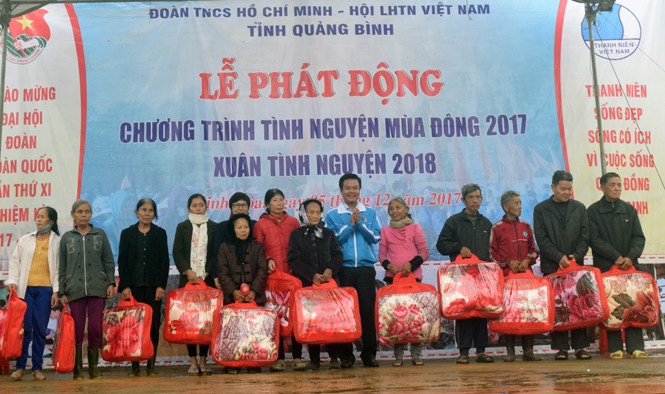 Đồng chí Trần Quốc Tuấn, Bí thư Tỉnh Đoàn trao quà cho các em học sinh Trường Tiểu học và THCS xã Xuân Hóa.