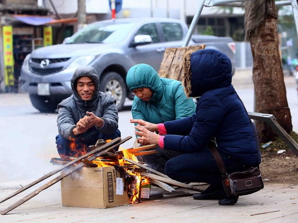 Người dân đốt củi để sưởi ấm tránh rét. (Ảnh: Quang Quyết/TTXVN)