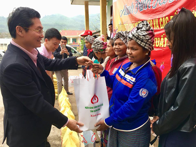 Ông Trần Văn Tài , Giám đốc NHCSXH chi nhánh Quảng Bình trao quà tết cho bà con xã Dân Hóa, huyện Minh Hóa