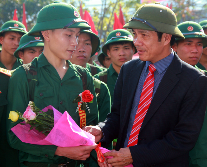 Ảnh 1. Đồng chí Nguyễn Công Huấn, Ủy viên Ban Thường vụ, Trưởng Ban Dân vận Tỉnh ủy tặng hoa, động viên con em huyện Minh Hóa trước lúc lên đường làm nhiệm vụ bảo vệ Tổ quốc.