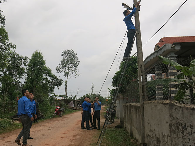 Các đoàn viên thanh niên đang kéo đường điện thắp sáng đường quê