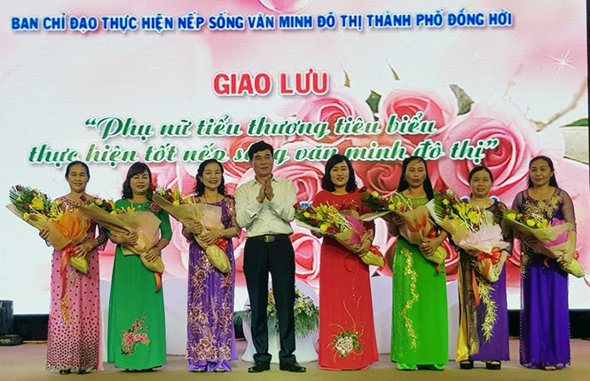 Đại diện lãnh đạo thành phố Đồng Hới tặng hoa cho các tiểu thương tiêu biểu trong phong trào thực hiện nếp sống văn minh đô thị.