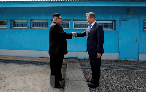 Tổng thống Hàn Quốc Moon Jae-in (phải) đón Nhà lãnh đạo Triều Tiên Kim Jong-un ở đường phân định ranh giới giữa hai miền tại làng đình chiến Panmunjom. (Nguồn: TTXVN)