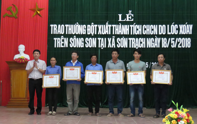 Đồng chí Nguyễn Ngọc Tuấn, Phó Chủ tịch UBND huyện Bố Trạch trao giấy khen và tiền thưởng của Chủ tịch UBND huyện cho 6 cá nhân dũng cảm cứu người.