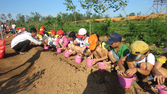 Được hướng dẫn tự tay xúc đất trồng cây.