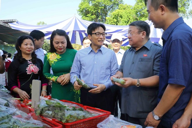 Phó Thủ tướng Vũ Đức Đam và các đại biểu tham quan gian hàng nông sản sạch. (Ảnh: Phương Hoa/TTXVN)