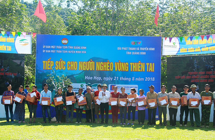Đại diện Ban Thường trực Ủy ban MTTQVN tỉnh trao quà của đoàn công tác lãnh đạo và đại biểu người uy tín trong đồng bào dân tộc thiểu số Thành phố Hồ Chí Minh cho các hộ có hoàn cảnh khó khăn trên địa bàn huyện Minh Hóa.