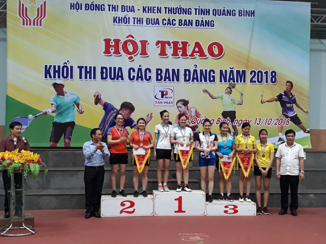 Ban tổ chức trao giải bộ môn cầu lông, nội dung đôi nữ cho các vận động viên.