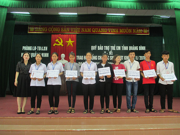 Đại diện lãnh đạo Quỹ Bảo trợ trẻ em tỉnh trao học bổng cho các em học sinh.