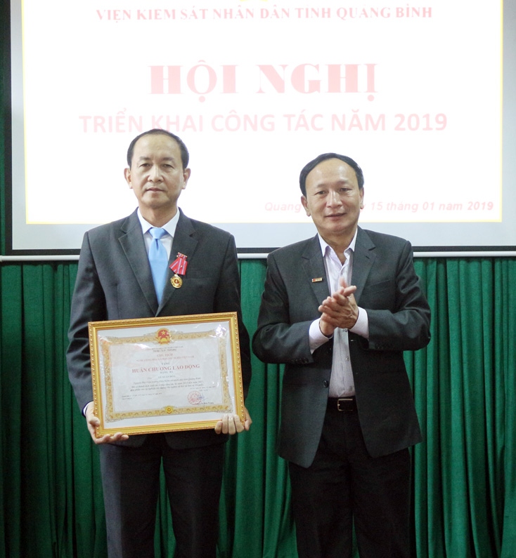 Đồng chí Trần Hải Châu, Ủy viên Thường vụ Tỉnh ủy, Trưởng ban Nội chính Tỉnh ủy trao Huân chương Lao động hạng 3 của Chủ tịch nước cho đồng chí Lê Xuân Hòa, nguyên Phó Viện trưởng VKSND tỉnh.  
