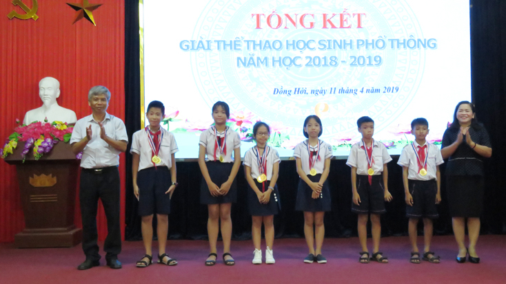 Lãnh đạo Phòng GD-ĐT Đồng Hới trao giải nhất môn Bơi lội cho các VĐV xuất sắc cấp tiểu học.