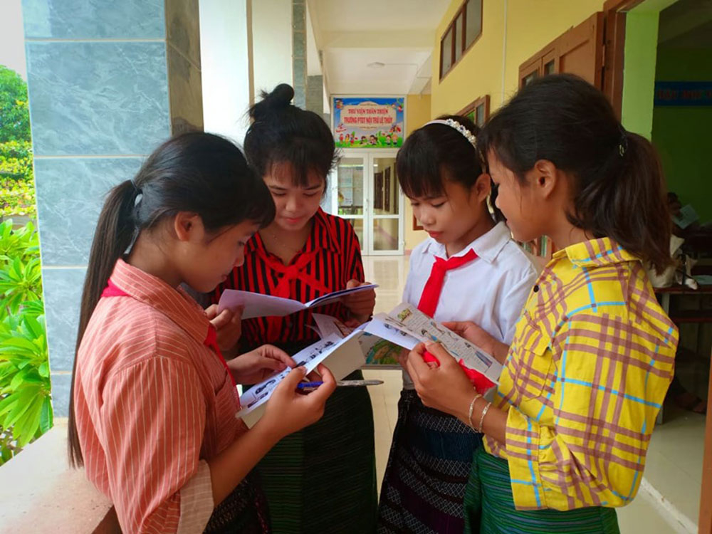 Các em học sinh đọc truyện tranh và tham gia thảo luận nhóm